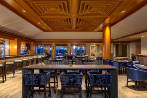 A modern restaurant with a bar, tables, and chairs.