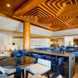 A modern restaurant with a bar, tables, and chairs.